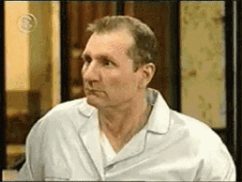 a man in a white pajama shirt is looking at the camera