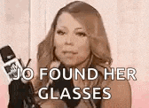 a woman is holding a microphone and talking into it while saying `` jo found her glasses '' .