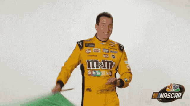 a man in a nascar uniform is holding a green object