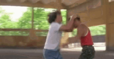 two men are fighting each other in a room in a building .