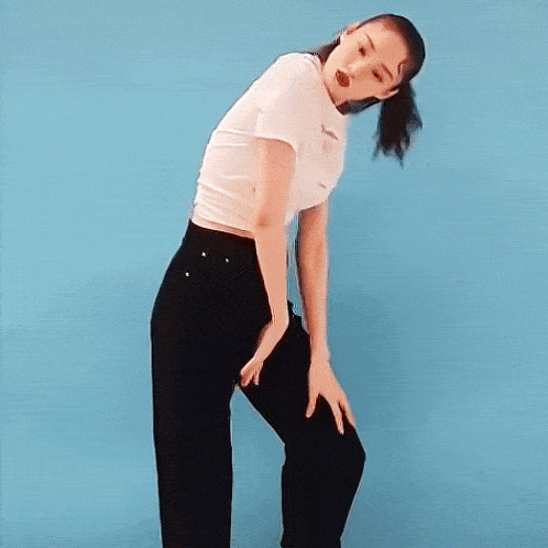 a woman wearing a white t-shirt and black pants is dancing against a blue background .