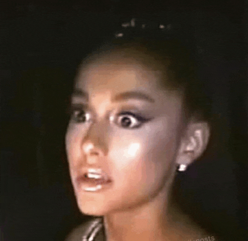 ariana grande is making a funny face with her mouth open in a close up of her face .