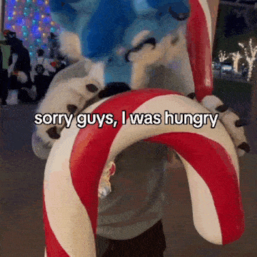 a person in a furry costume holding a candy cane that says sorry guys i was hungry on it