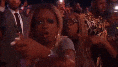 a crowd of people are sitting in a dark room watching a concert .