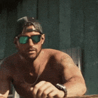 a shirtless man wearing sunglasses and a baseball cap is running .
