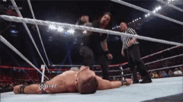 a man is laying on the ground in a wrestling ring with the word w live on the bottom