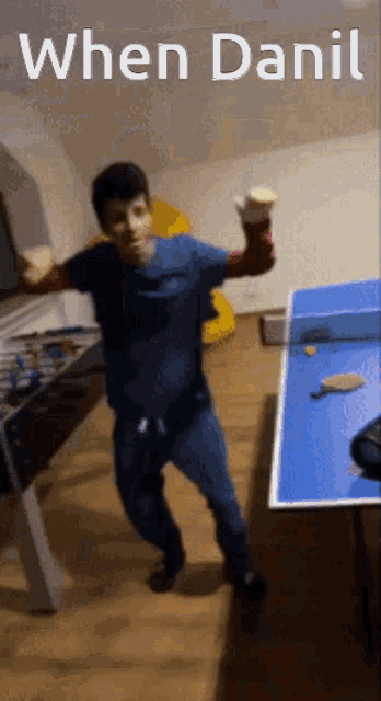 a man is dancing in front of a ping pong table with the words " when danil " on the bottom