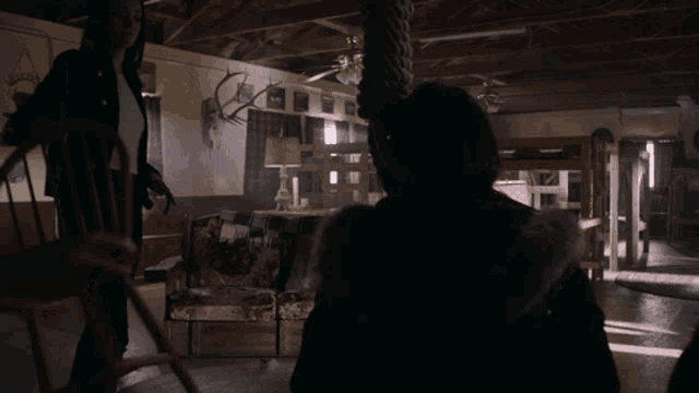 a woman is hanging from a rope in a room