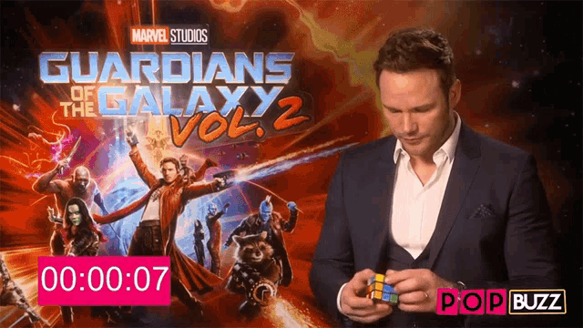 a man holding a rubik 's cube in front of guardians of the galaxy vol 2