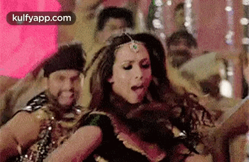 a woman is dancing in a crowd of people .