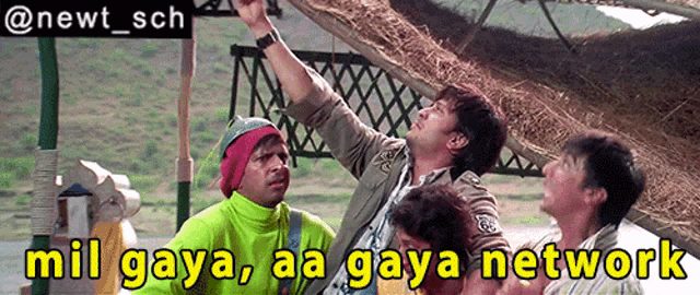 a group of men standing under a thatched roof with a caption that says mil gaya aa gaya network