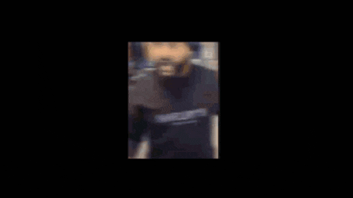 a man in a shelby sweatshirt is standing in a kitchen