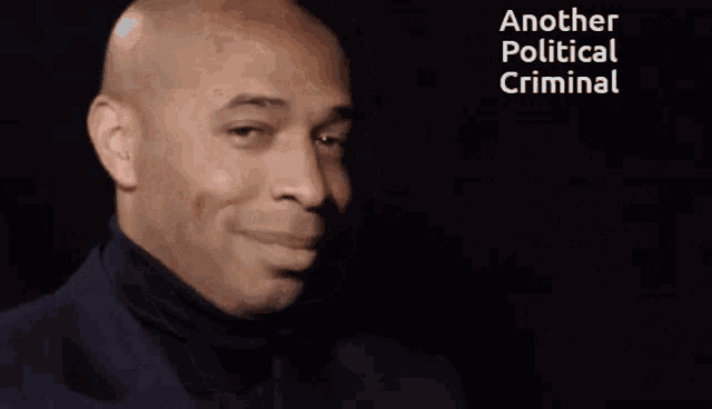 a man in a black turtleneck is smiling with the words another political criminal below him