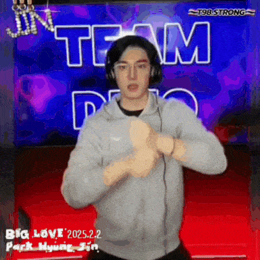 a man wearing headphones is dancing in front of a team logo