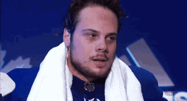 a man with a towel around his neck and a toronto maple leafs jersey on