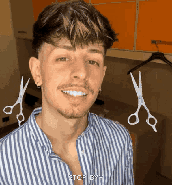 a man in a striped shirt is smiling with scissors behind him and the words stop byy