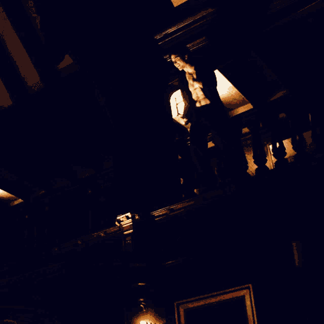 a person standing on a balcony with a light on