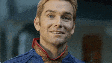 a close up of a man 's face with a blue shirt and red collar .