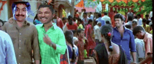 two men are standing in front of a crowd of people and one of them has a green shirt on .