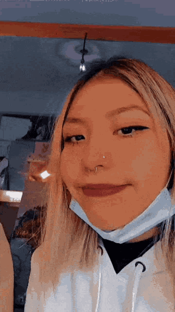 a woman with a nose ring and a face mask