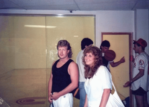 a group of people standing in a room with one wearing a jersey that says ' a' on it