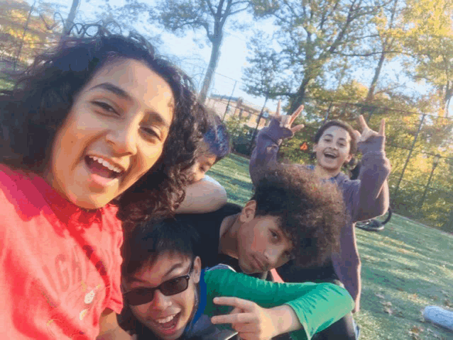 a group of young people are posing for a picture and one of them is wearing a red shirt that says ' a '