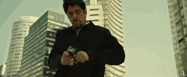 a man in a suit is holding a gun in front of a city skyline