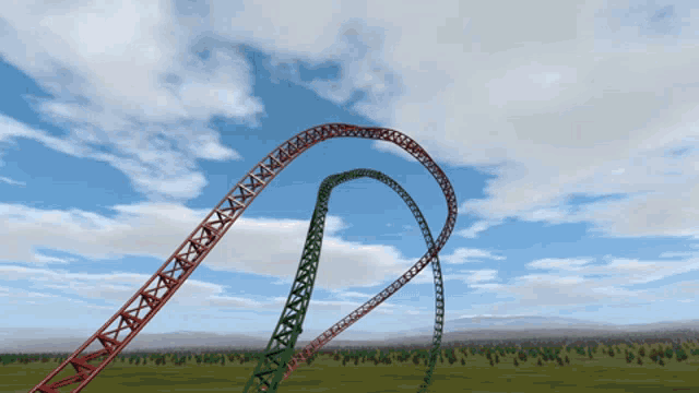 a roller coaster going through a grassy field with trees in the background