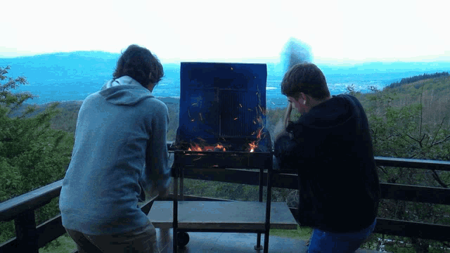 two men are looking at a fire on a balcony