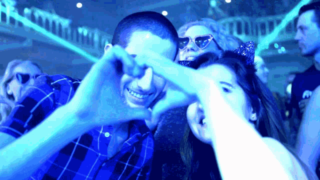 a group of people are making a heart with their hands