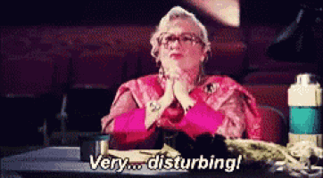 an elderly woman is sitting at a desk and saying very disturbing !
