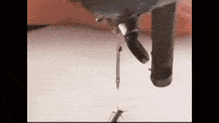 a close up of a person holding a needle and a bug .
