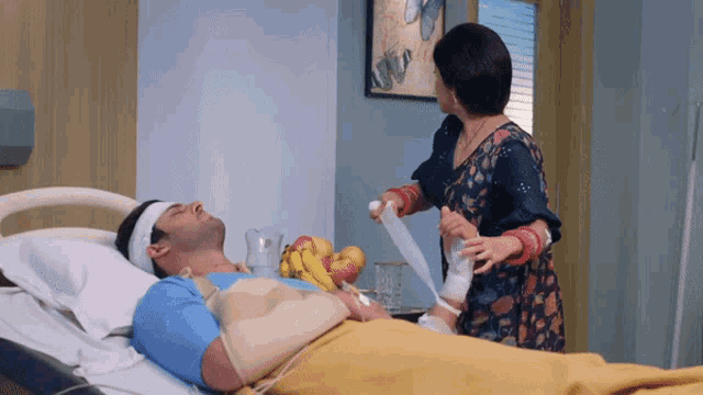 a man with a bandage on his head is laying in a hospital bed