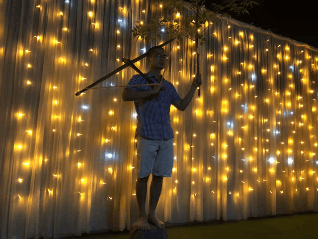 a man standing in front of a white curtain with lights on it
