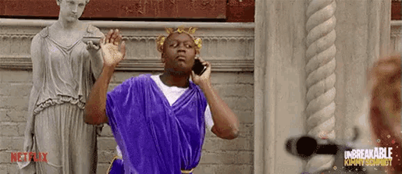 a man in a purple toga is talking on a cell phone .