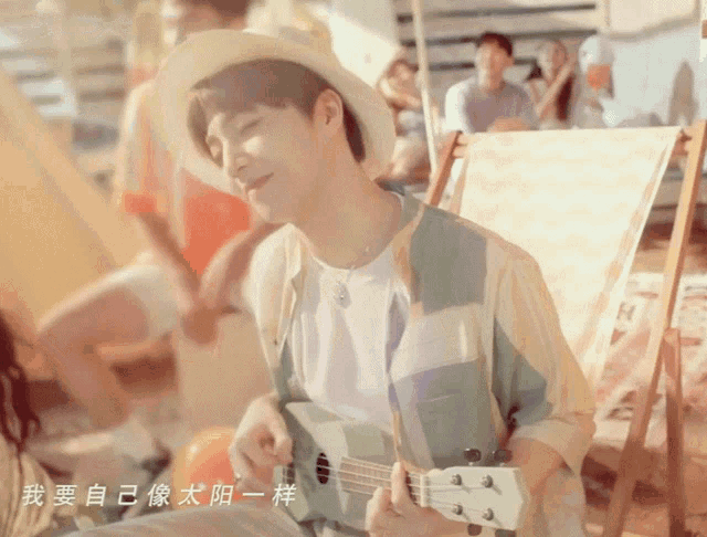 a man in a hat is playing an ukulele with chinese writing on the bottom