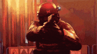a pixel art drawing of a man holding a gun with a x on his helmet