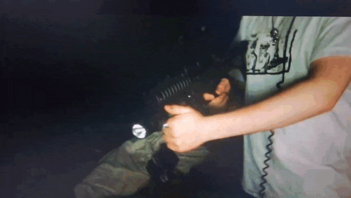 a man is holding a flashlight in his right hand