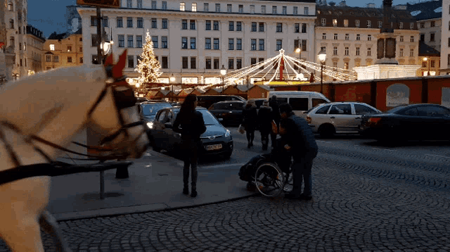 a man in a wheelchair is pushed by a horse drawn carriage