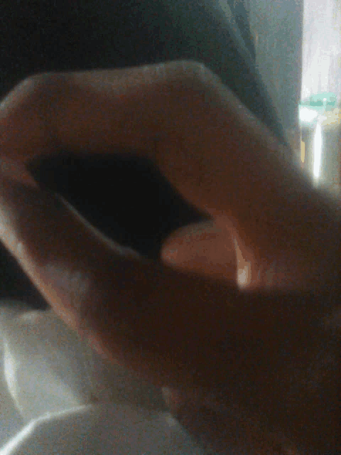 a close up of a person 's hand with a ring on it