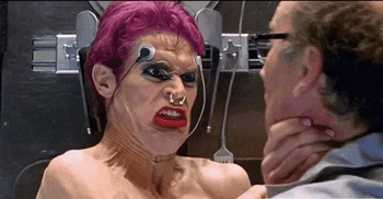 a woman with pink hair is making a funny face while a man holds her neck in a room .