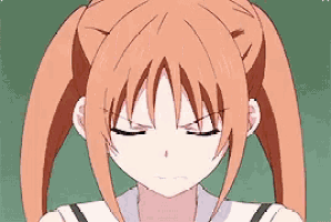a close up of a girl with orange hair and pigtails making a funny face .