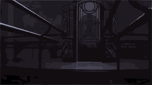 a dark room with a stained glass door and stairs