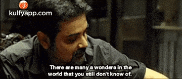 a man is sitting at a table with a quote that says there are many wonders in the world that you still don 't know of
