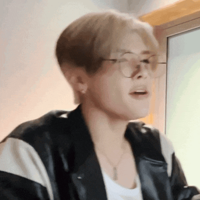 a close up of a person wearing glasses and a black jacket .