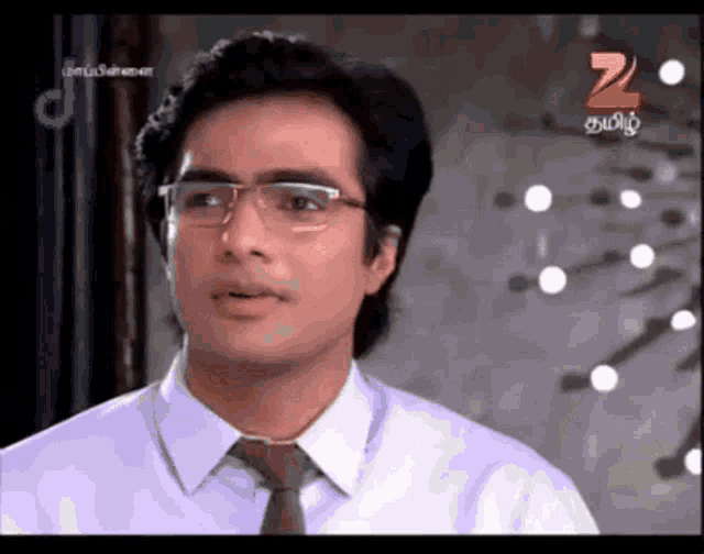 a man wearing glasses and a tie is on a television screen with the number 20 on it