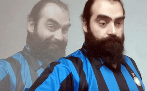 a man with a beard is wearing a blue and black striped shirt with a star on it