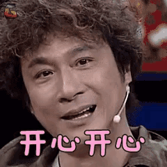 a man with curly hair is wearing a microphone around his neck and making a funny face .