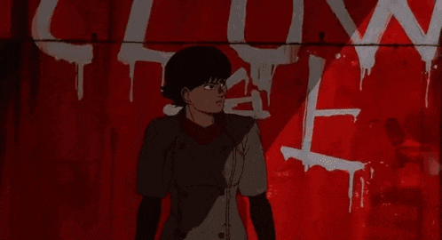 a woman in a trench coat is standing in front of a red wall .