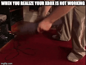 a man is kneeling down on a red carpet while playing a video game on his xbox .
